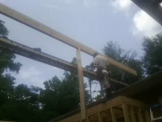 Carpenter setting a ridge beam over a new addition frame — Ice Dam Removal by Roofing Brothers in Lawrenceburg